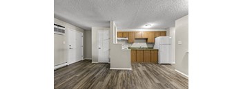 A kitchen with wooden floors and white appliances.