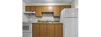 A kitchen with wooden cabinets and a white refrigerator.
