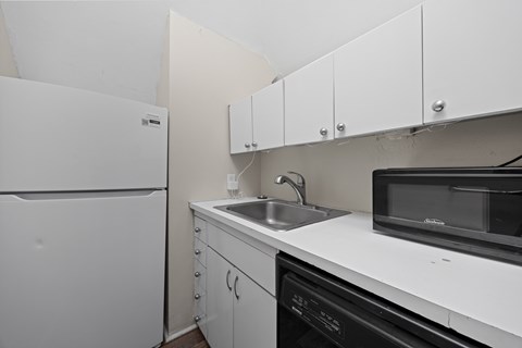 A white fridge and microwave in a kitchen.