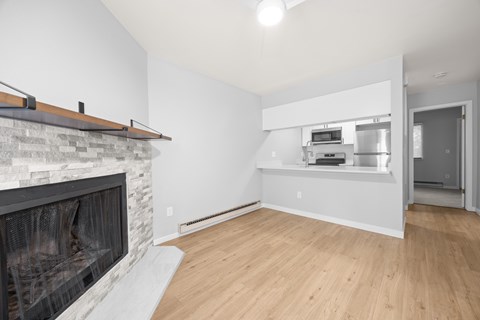 A modern living room with a stone fireplace and wooden flooring.