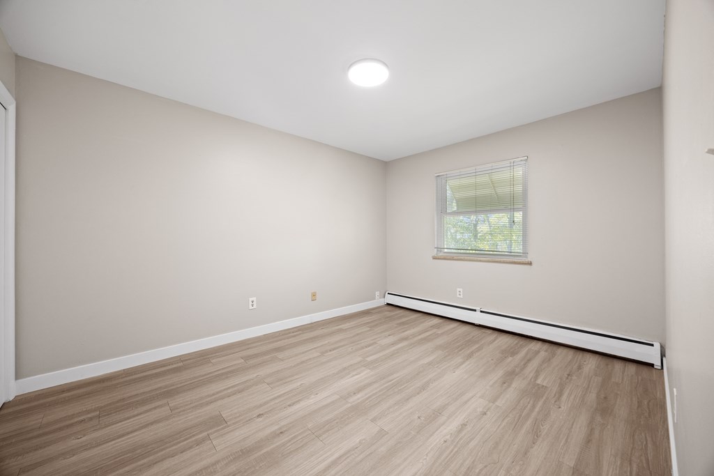 A room with wooden flooring and a window.
