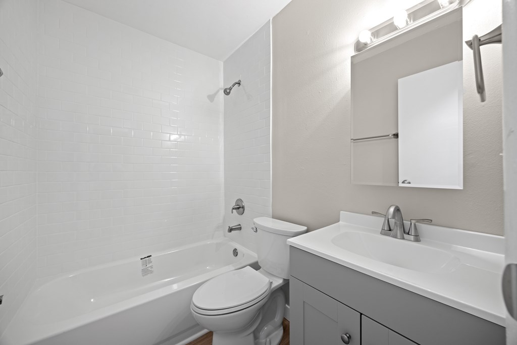 A white bathroom with a toilet, sink, and bathtub.