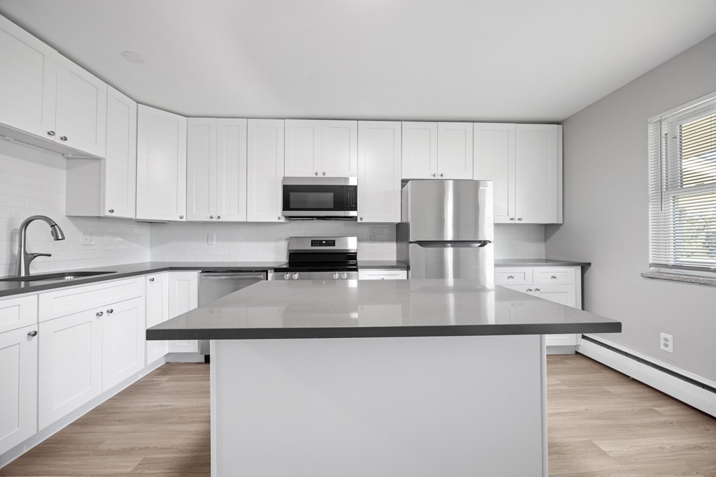 A modern kitchen with white cabinets and a central island.