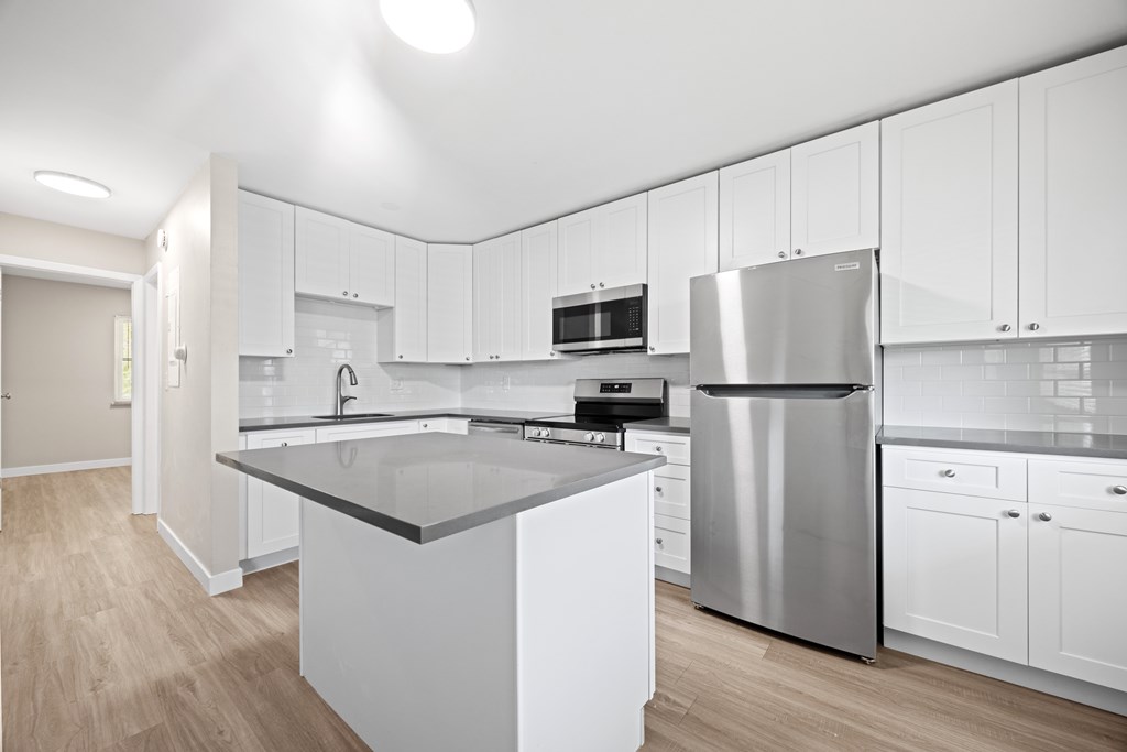 A modern kitchen with a large island and stainless steel appliances.
