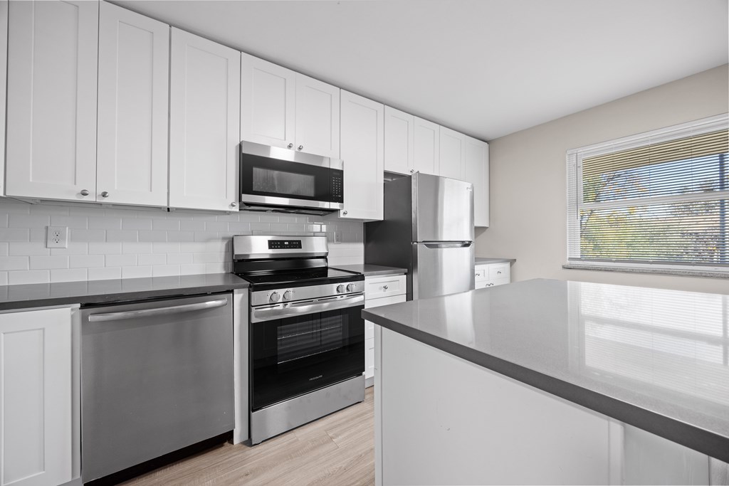 A modern kitchen with stainless steel appliances and white cabinets.