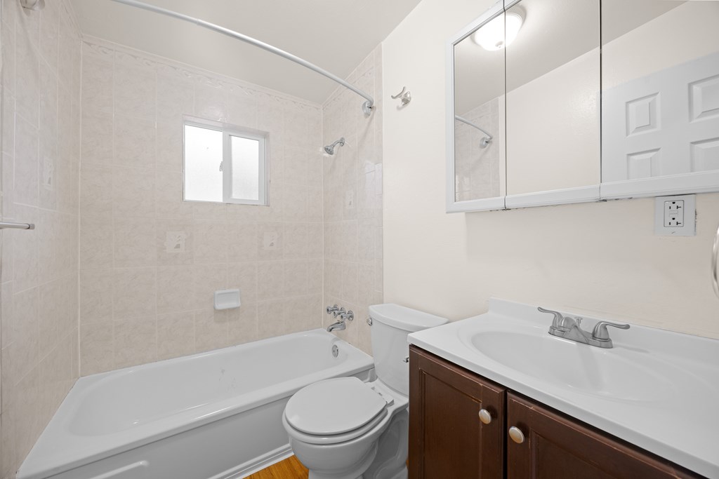 A white bathroom with a tub, toilet and sink.