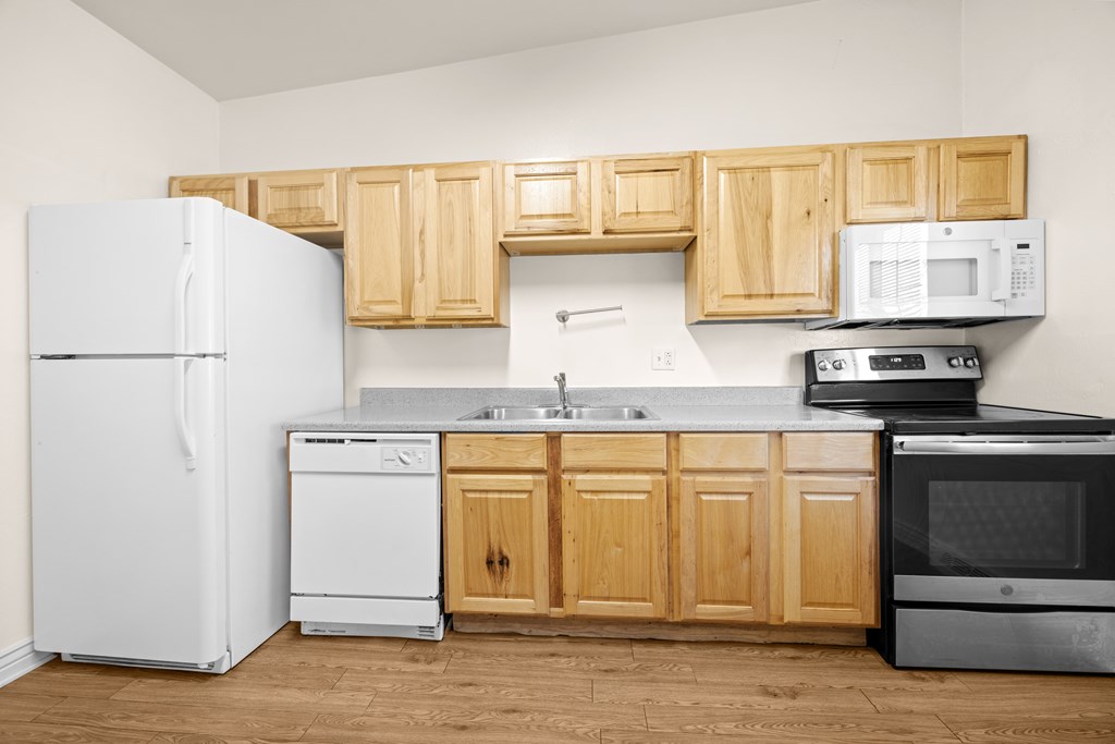 A kitchen with wooden cabinets and white appliances.