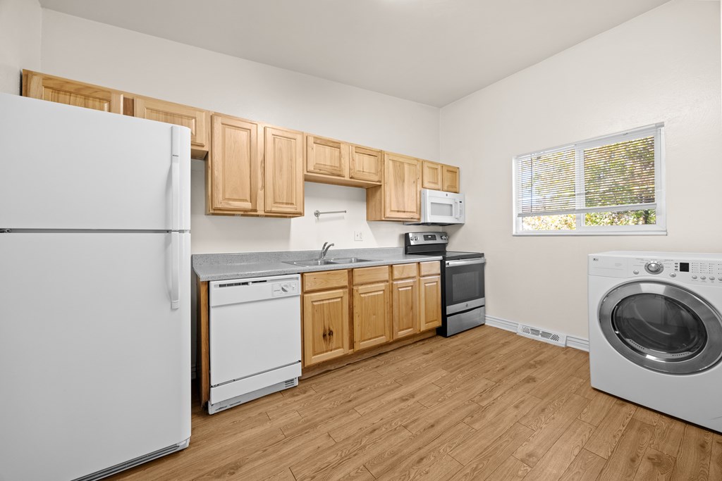 A kitchen with wooden cabinets and white appliances.