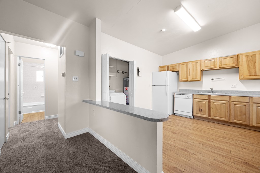A kitchen area with wooden cabinets and a grey countertop.