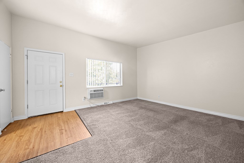 A room with a white door and a window with blinds.