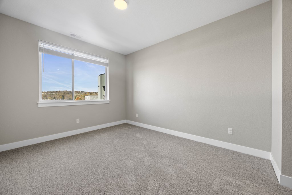 Empty room with a window overlooking a landscape.