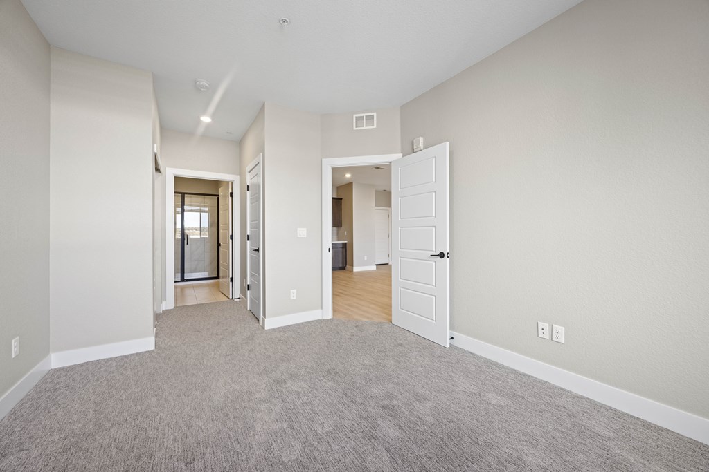 A spacious room with a carpeted floor and white walls.