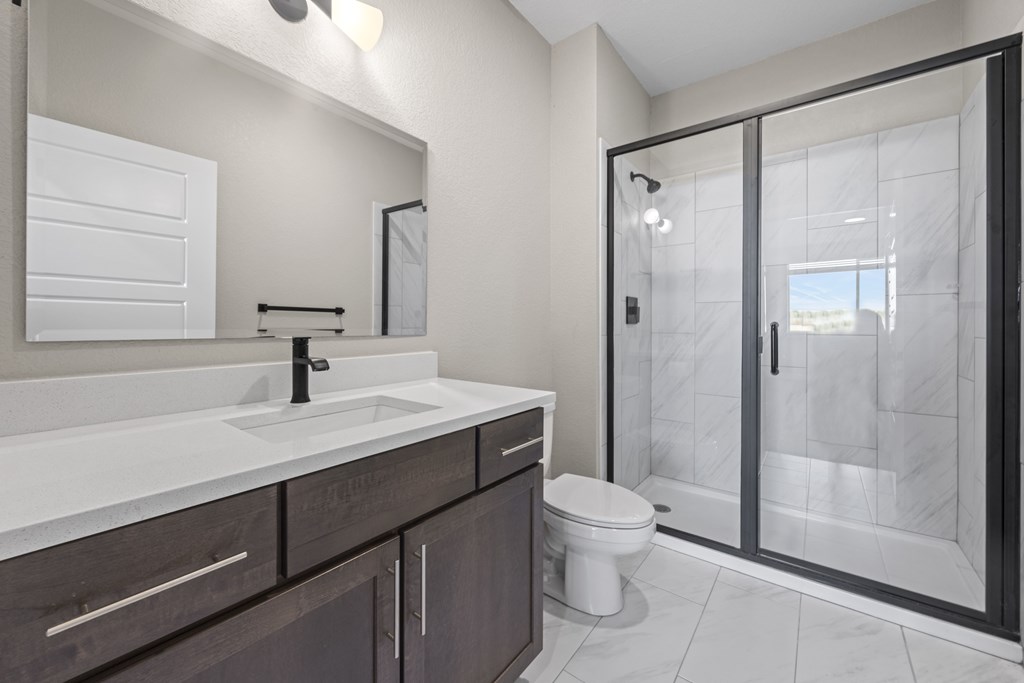 A bathroom with a white sink and a toilet.