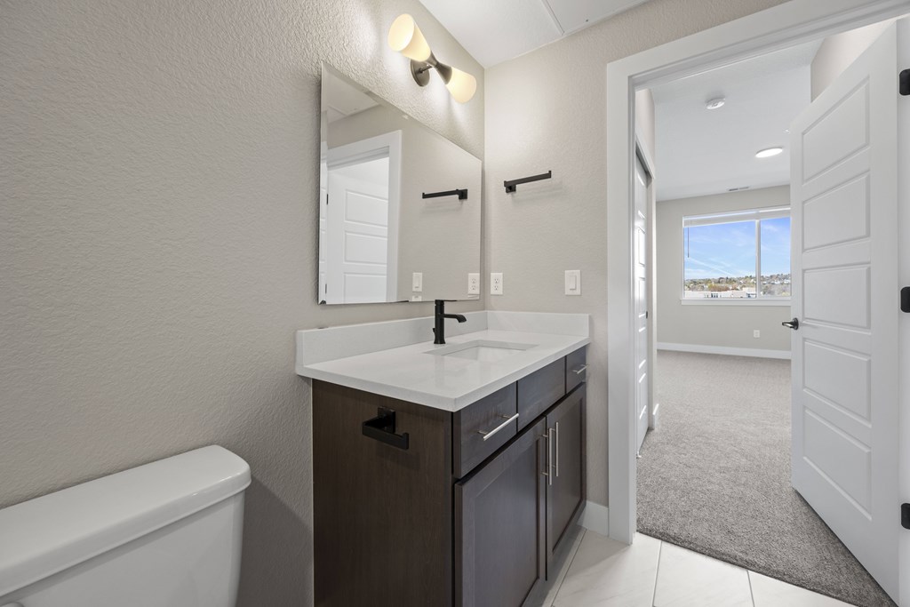 A bathroom with a white tub and a sink with a mirror above it.