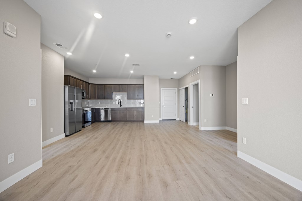 A spacious kitchen with a refrigerator, sink, and cabinets.
