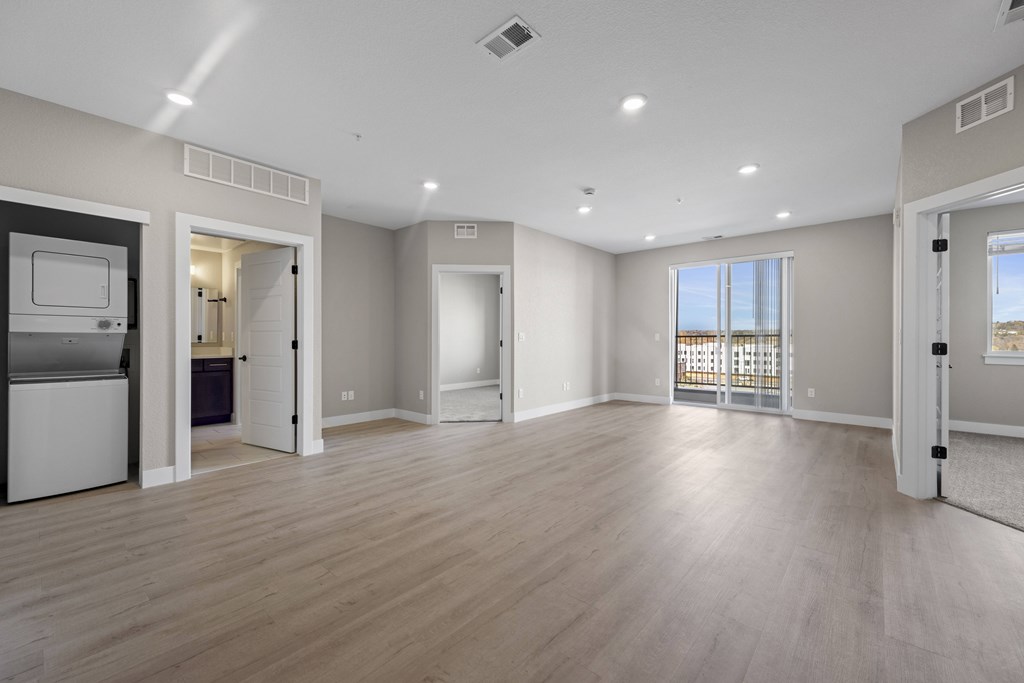 A spacious room with wooden flooring and white walls.