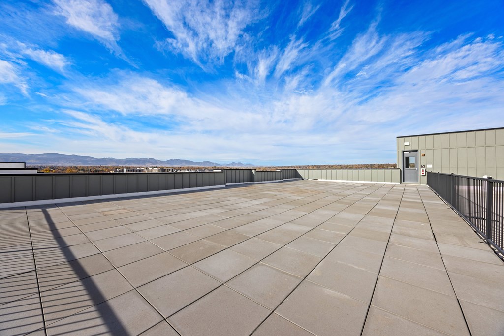 A rooftop with a clear blue sky and a building on the right side.