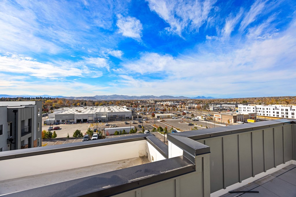 A view from a high-rise building looking down at a parking lot and buildings below.
