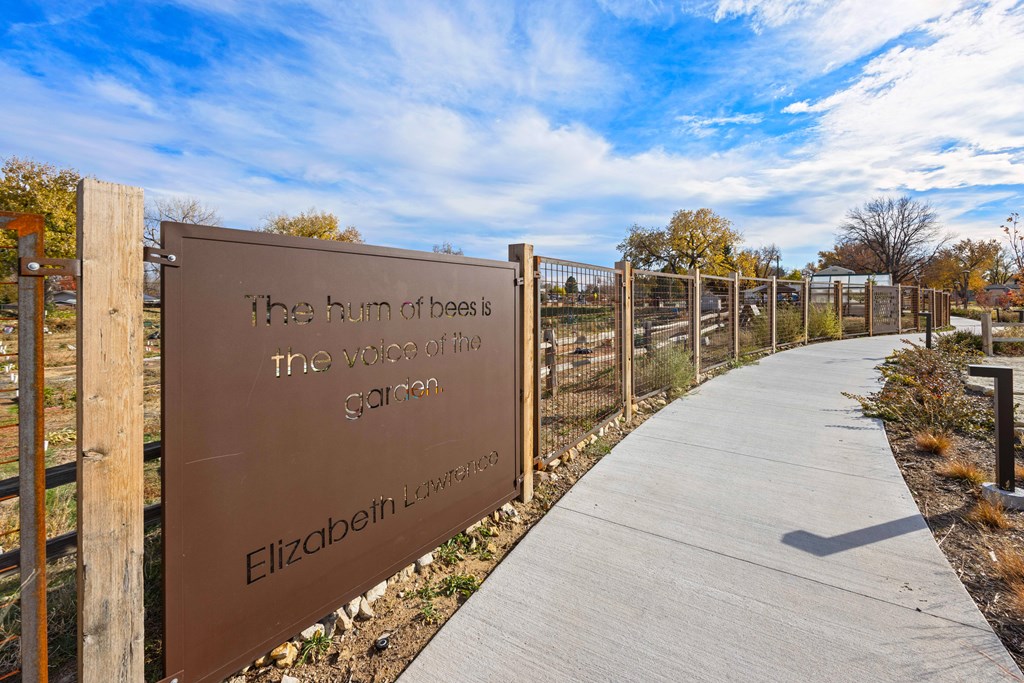 A sign that says "The hum of bees is the voice of the garden" by Elizabeth Lawes.