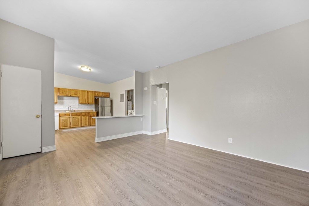 A large empty room with wooden floors and white walls.