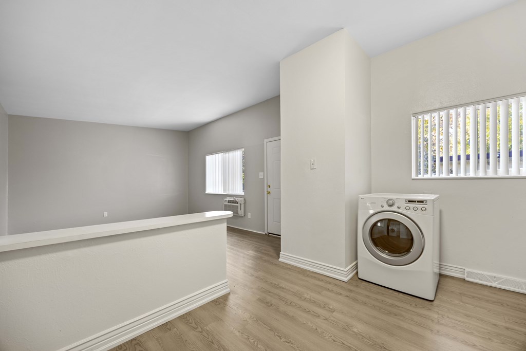 A laundry room with a washing machine and a window.