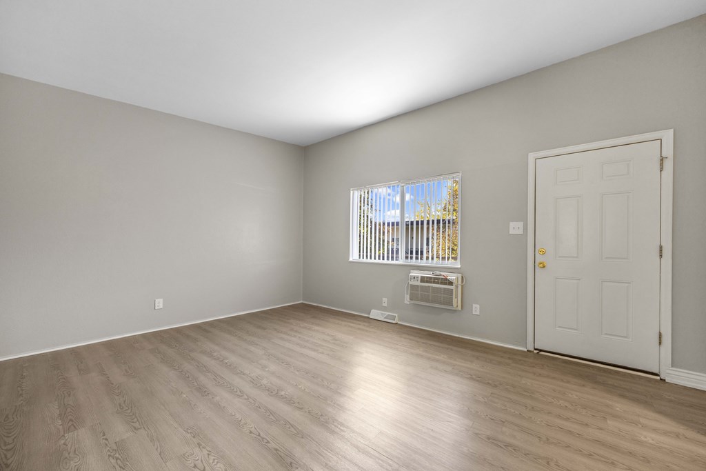 A room with a white door and a window with blinds.