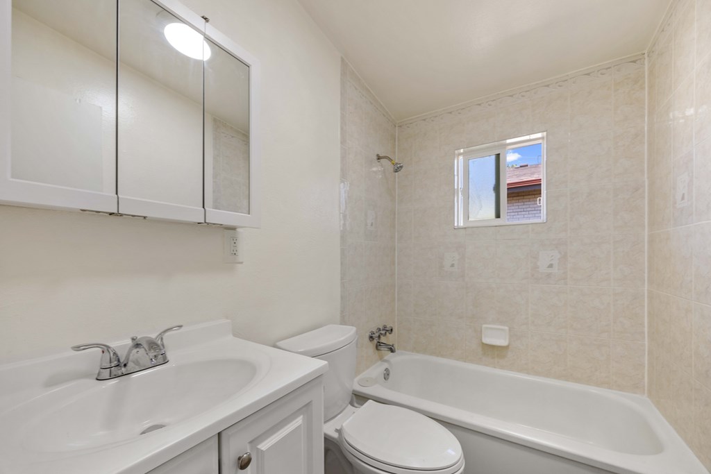 A white bathroom with a sink, toilet, and bathtub.