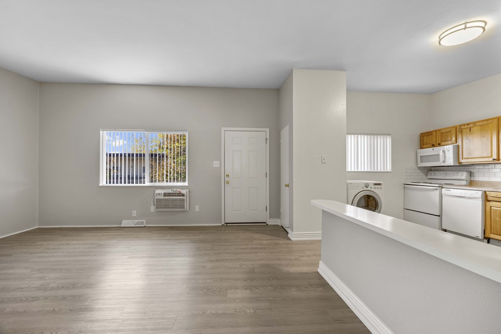 A clean, empty room with a window, a door, and a counter.