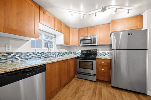 A kitchen with wooden cabinets and stainless steel appliances.