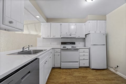 A kitchen with white cabinets and appliances.