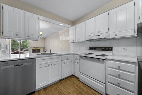 A kitchen with white cabinets and appliances.