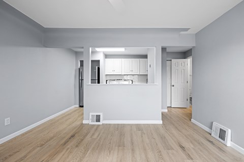 A kitchen area with a refrigerator, cabinets, and a countertop.