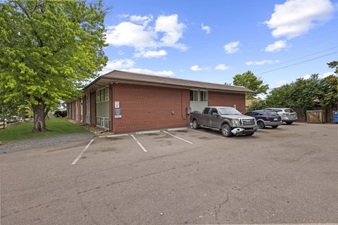 A parking lot with a building and cars.