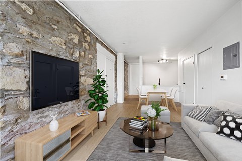 A living room with a stone wall and a flat screen TV.