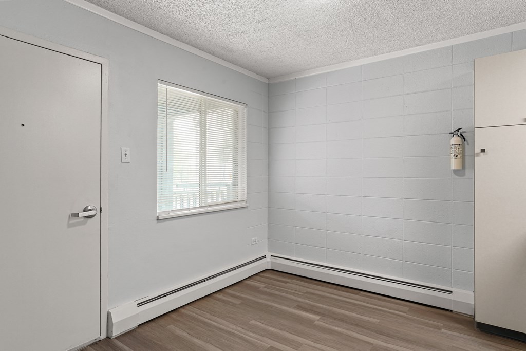 a bedroom with white walls and hardwood floors