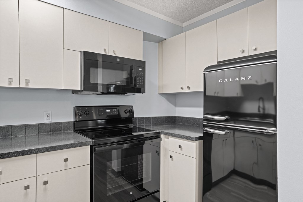 a kitchen with white cabinets and black and white appliances