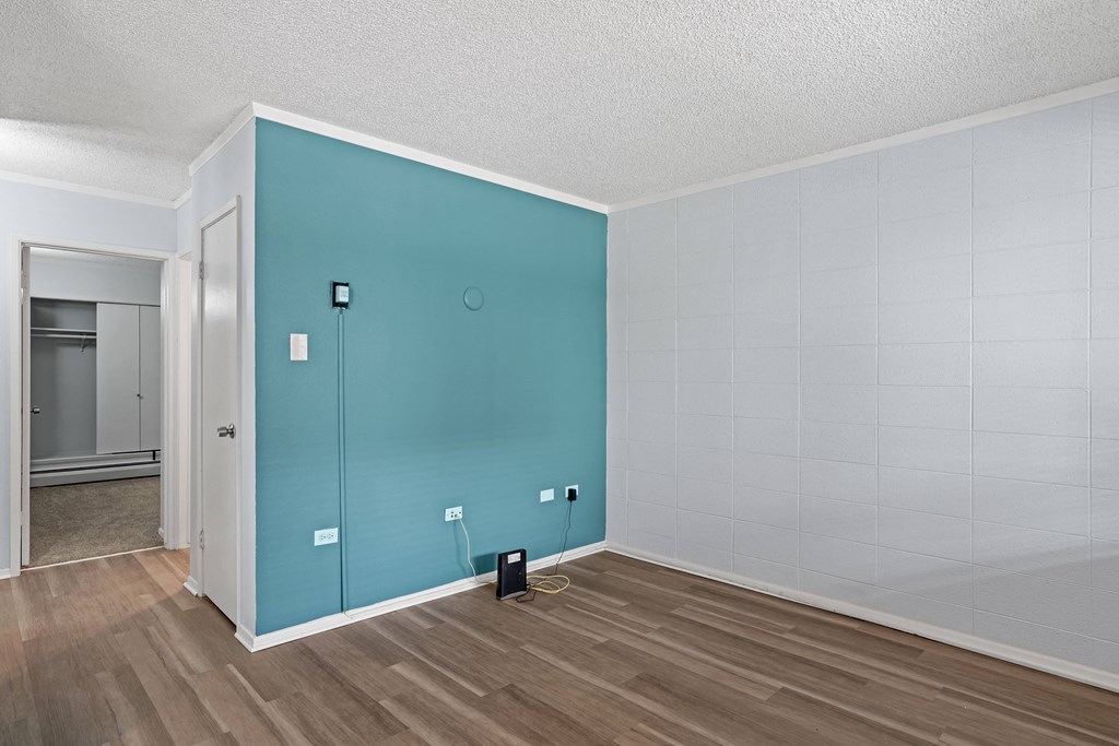 a room with a hardwood floor and a blue wall