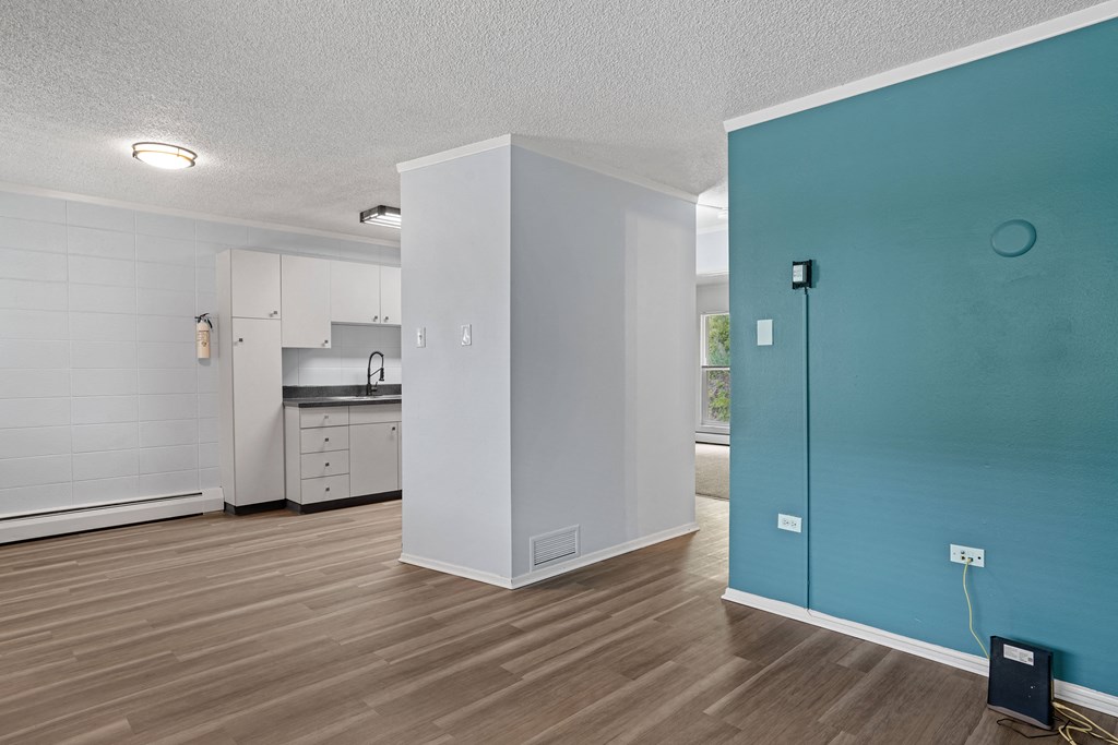 a living room with a blue door and a kitchen in the background