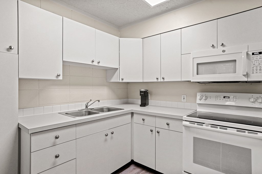 a kitchen with white cabinets and white appliances