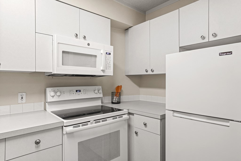 a kitchen with white cabinets and white appliances