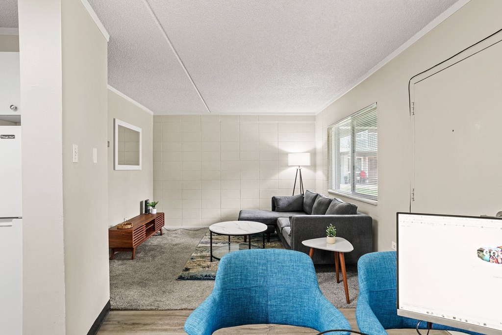a living room with white walls and blue furniture