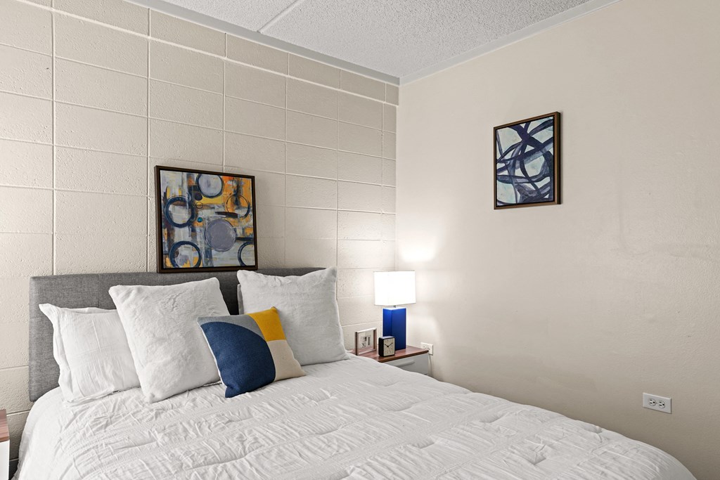 a bedroom with a bed and two paintings on the wall