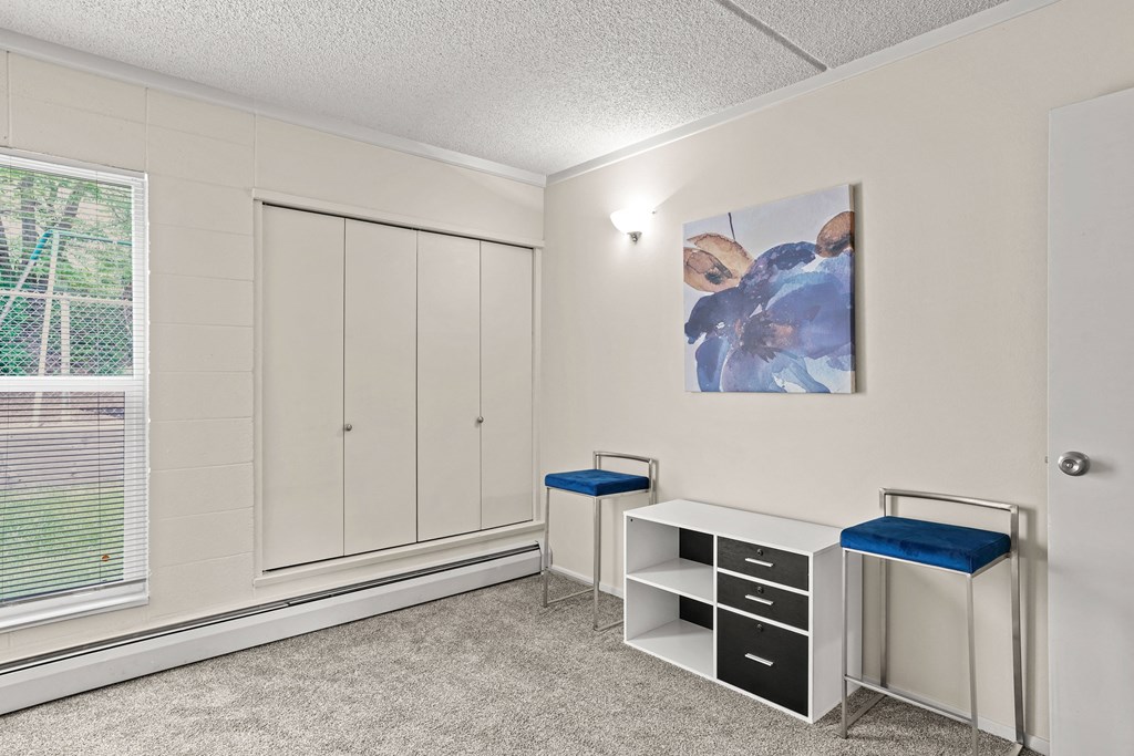 a counselling room with two stools and a cabinet with two drawers