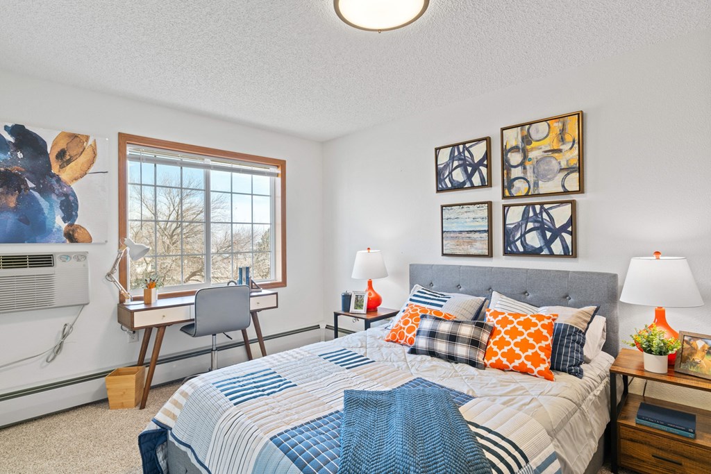 a bedroom with a bed and a desk with a computer