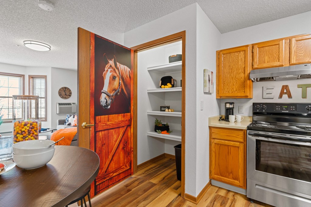 a kitchen and dining room with a table and chairs and a painting of a horse on the