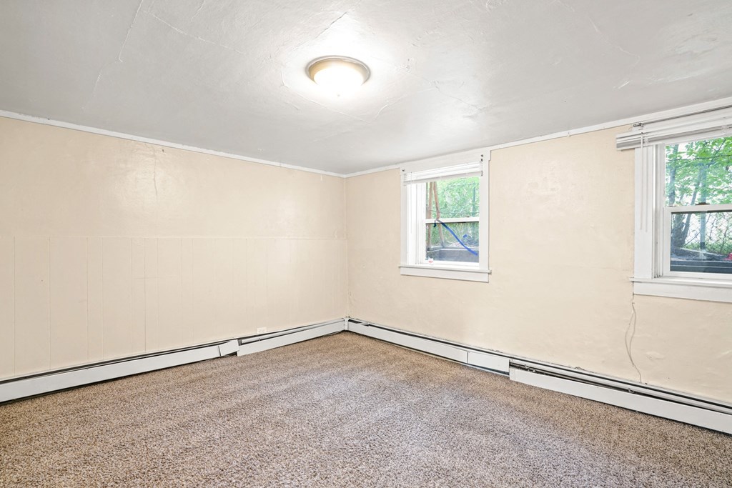 A room with a window and carpeted floor.