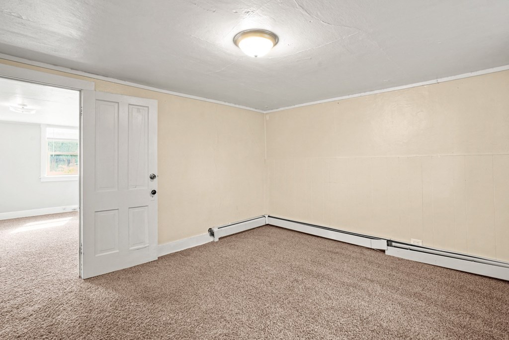 A room with a carpeted floor and a white door.