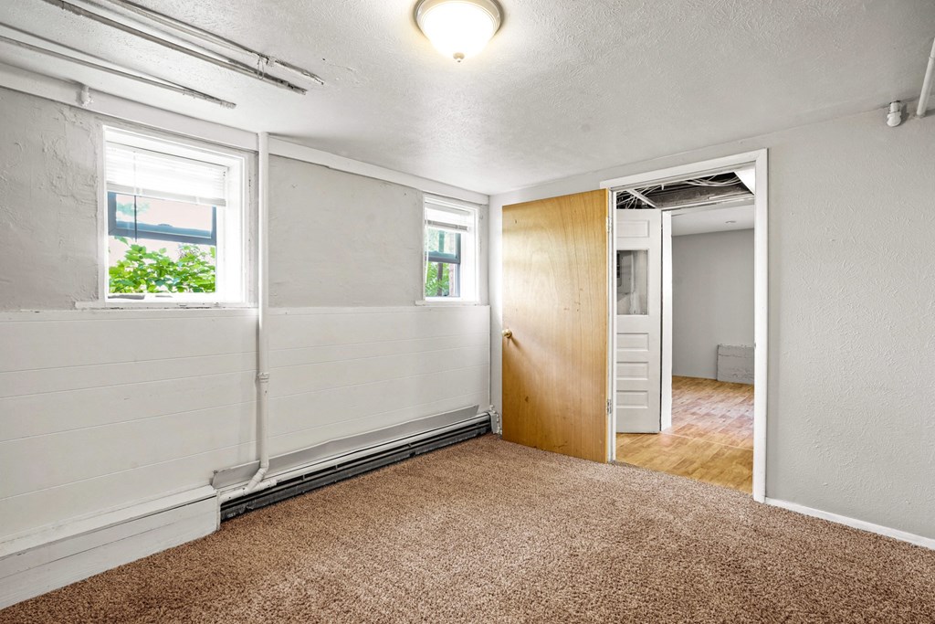 A room with a brown carpet and a white wall.