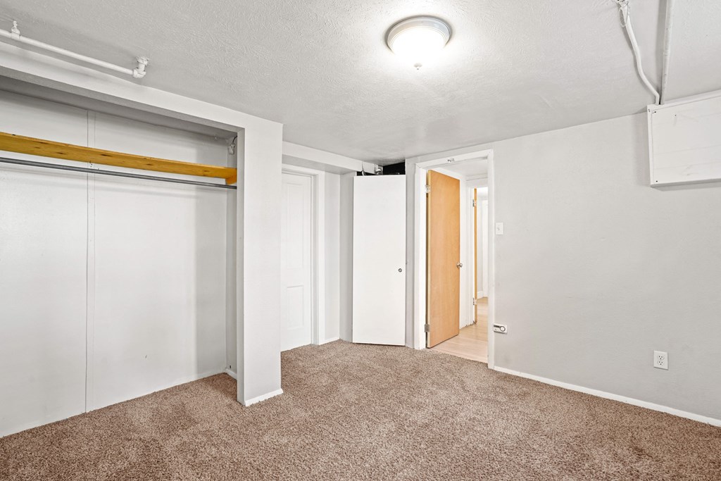 A room with white walls and a brown carpet.