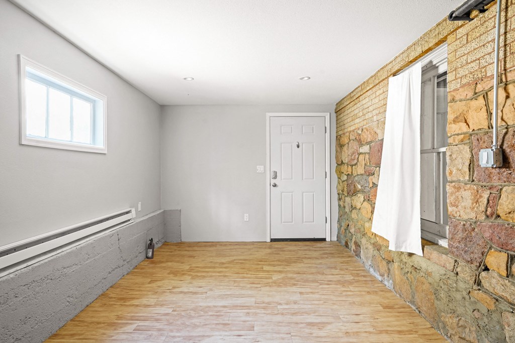 A room with a white door and a window with a white curtain.